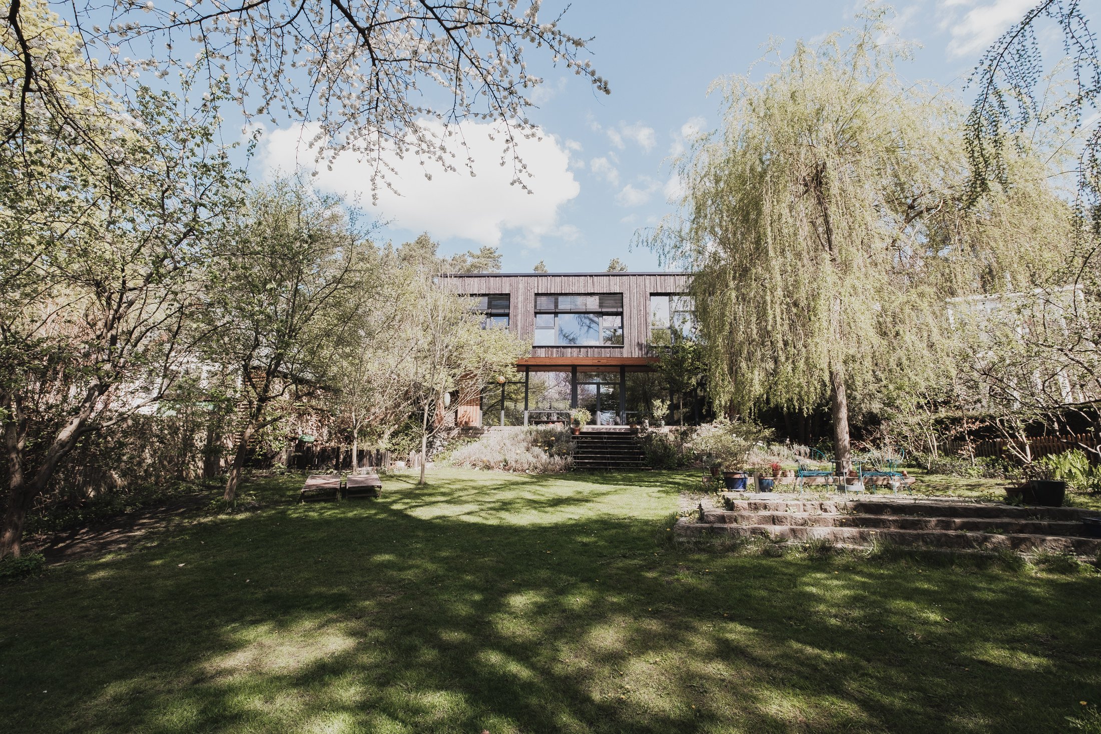 Garten mit Trauerweide und Blick auf das Haus, Das schwarze Haus